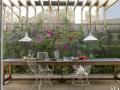 Teriér Jack je doma v jednom ze "zahradních pokojů" brazilské vily, kterou navrhl Isay Weinfeld. Floristický pracovní stůl doplňují železné vintage židle (Foto: Ngoc Minh Ngo)